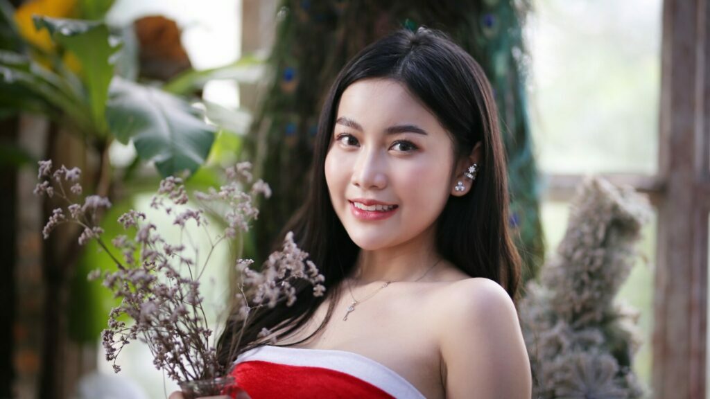 wanita muda yang cantik gembira memakai kostum krismas seksi - gaun merah dan santa claus