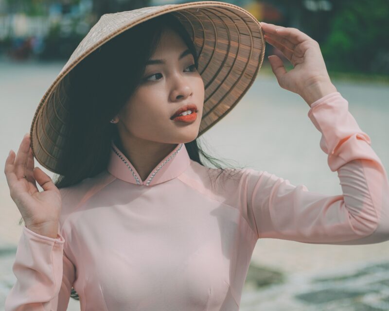원추형 모자를 쓴 아오자이를 입은 아름다운 베트남 소녀