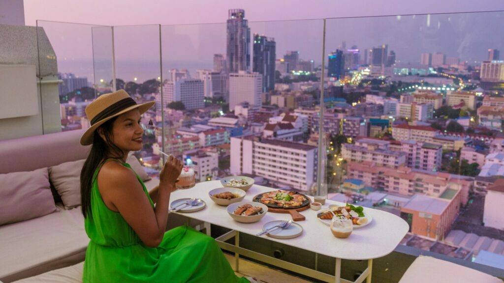 wanita muda sedang minum di bar atas bumbung